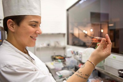 Anastasia Paris nella sua cucina con il finestrone sulla sala del ristorante.