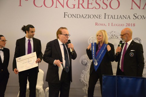 la responsabile della didattica Daniela Scrobogna mostra la fascia di Miglior Sommelier del Mondo 2018